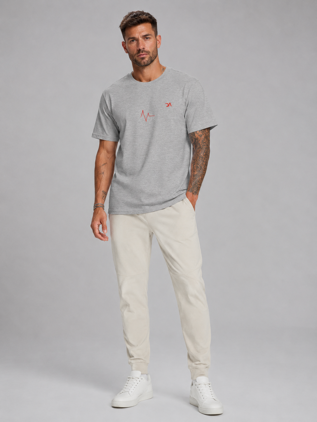 Man wearing a gray t-shirt with a red logo and beige pants on a gray background